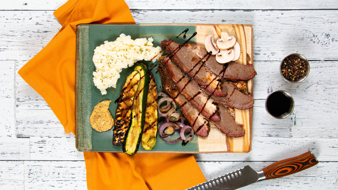 Smoked Beef Brisket on a platter with grilled veggies and mustard